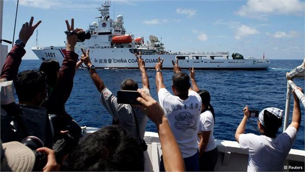 資料圖：菲律賓漁船突破中國海警船包圍，為仁愛礁上被困人員運送補給。漁船上的軍民對海警船比出手勢。