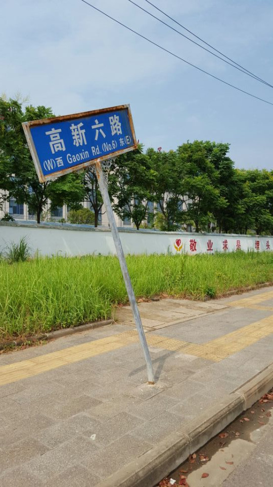 今日上午,在武汉市东湖高新区一人行道上,公路指示牌多日歪歪,无人管