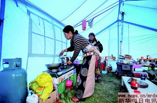 四川省阿坝藏族羌族自治州若尔盖县的一名藏族妇女在帐篷内做饭