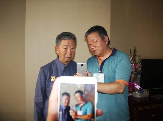 老兵邱玉的儿子邱树星教父亲如何使用手机。新华网北京频道发