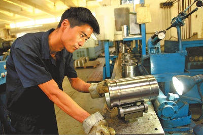 8月27日,河南中原吉凯恩气缸套有限公司员工正在车间抓紧生产配件.