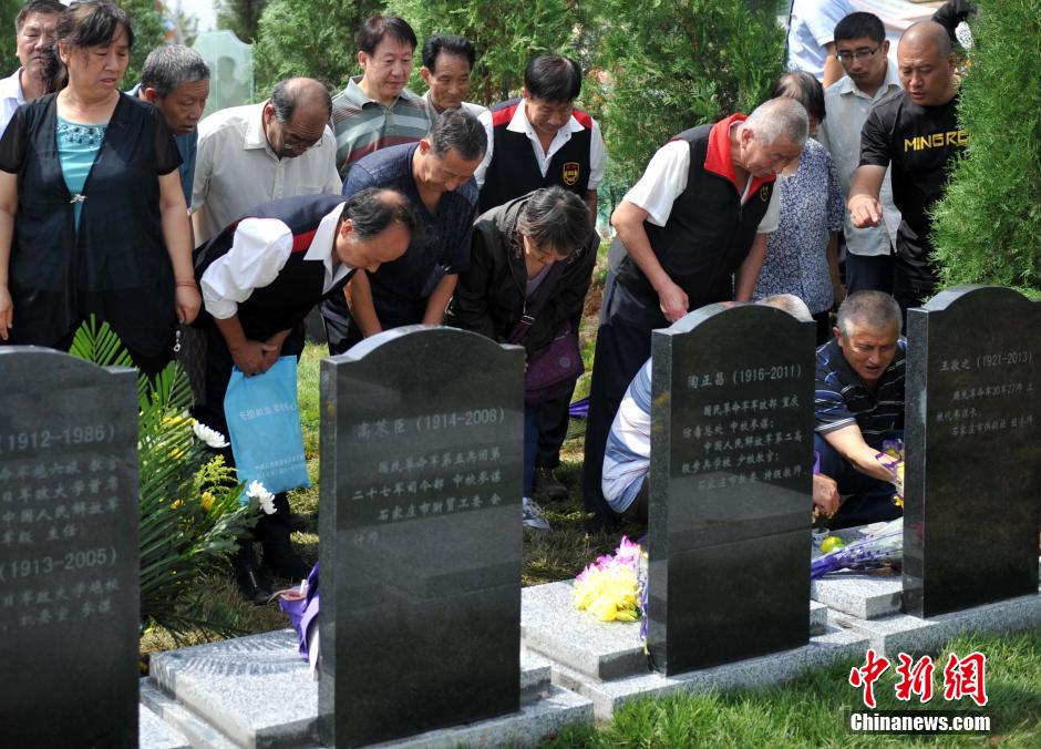 8月31日，位于河北省元氏县的神岩山公墓，工作人员正免费为首批12名抗战老兵完成安葬仪式。据了解，为纪念中国人民抗战胜利暨世界反法西斯战争胜利70周年，神岩山公墓特别设立了“抗战老兵墓区”，并免费提供100个墓位无偿捐献给抗战老兵，让他们能入土为安。墓碑上刻有老兵及其配偶姓氏、生卒时间、部队番号及主要抗战事迹。图为抗战老兵家属、朋友来到墓碑前祭奠。中新社发 翟羽佳 摄