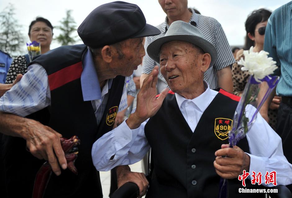 8月31日，位于河北省元氏县的神岩山公墓，工作人员正免费为首批12名抗战老兵完成安葬仪式。据了解，为纪念中国人民抗战胜利暨世界反法西斯战争胜利70周年，神岩山公墓特别设立了“抗战老兵墓区”，并免费提供100个墓位无偿捐献给抗战老兵，让他们能入土为安。墓碑上刻有老兵及其配偶姓氏、生卒时间、部队番号及主要抗战事迹。图为抗战老兵家属、朋友来到墓碑前祭奠。中新社发 翟羽佳 摄