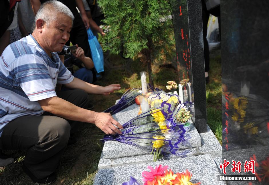 8月31日，位于河北省元氏县的神岩山公墓，工作人员正免费为首批12名抗战老兵完成安葬仪式。据了解，为纪念中国人民抗战胜利暨世界反法西斯战争胜利70周年，神岩山公墓特别设立了“抗战老兵墓区”，并免费提供100个墓位无偿捐献给抗战老兵，让他们能入土为安。墓碑上刻有老兵及其配偶姓氏、生卒时间、部队番号及主要抗战事迹。图为抗战老兵家属、朋友来到墓碑前祭奠。中新社发 翟羽佳 摄