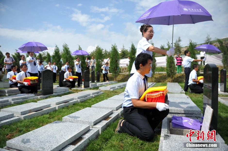 8月31日，位于河北省元氏县的神岩山公墓，工作人员正免费为首批12名抗战老兵完成安葬仪式。据了解，为纪念中国人民抗战胜利暨世界反法西斯战争胜利70周年，神岩山公墓特别设立了“抗战老兵墓区”，并免费提供100个墓位无偿捐献给抗战老兵，让他们能入土为安。墓碑上刻有老兵及其配偶姓氏、生卒时间、部队番号及主要抗战事迹。图为抗战老兵家属、朋友来到墓碑前祭奠。中新社发 翟羽佳 摄