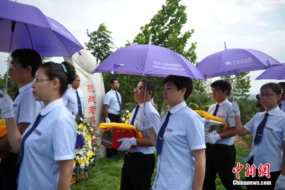 8月31日，位于河北省元氏县的神岩山公墓，工作人员正免费为首批12名抗战老兵完成安葬仪式。据了解，为纪念中国人民抗战胜利暨世界反法西斯战争胜利70周年，神岩山公墓特别设立了“抗战老兵墓区”，并免费提供100个墓位无偿捐献给抗战老兵，让他们能入土为安。墓碑上刻有老兵及其配偶姓氏、生卒时间、部队番号及主要抗战事迹。图为抗战老兵家属、朋友来到墓碑前祭奠。中新社发 翟羽佳 摄