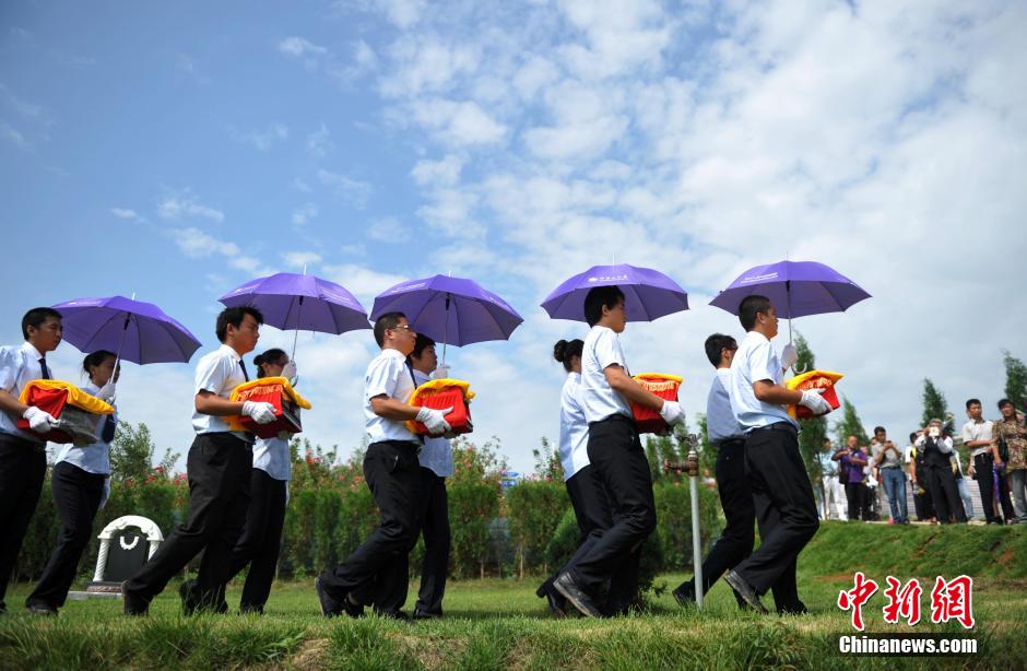 8月31日，位于河北省元氏县的神岩山公墓，工作人员正免费为首批12名抗战老兵完成安葬仪式。据了解，为纪念中国人民抗战胜利暨世界反法西斯战争胜利70周年，神岩山公墓特别设立了“抗战老兵墓区”，并免费提供100个墓位无偿捐献给抗战老兵，让他们能入土为安。墓碑上刻有老兵及其配偶姓氏、生卒时间、部队番号及主要抗战事迹。图为抗战老兵家属、朋友来到墓碑前祭奠。中新社发 翟羽佳 摄