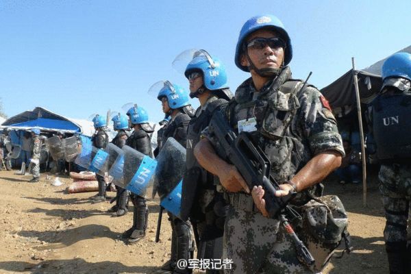 中国维和部队持枪举盾护卫难民
