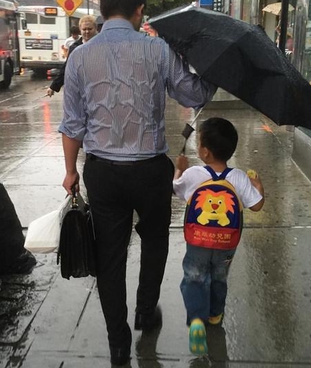 父亲全身湿透为儿子撑伞感动多人该父亲是谁资