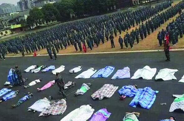 20多名女生躺在沥青跑道上,身上结结实实地裹着棉被,承受太阳的照晒和两千余名同窗的围观。