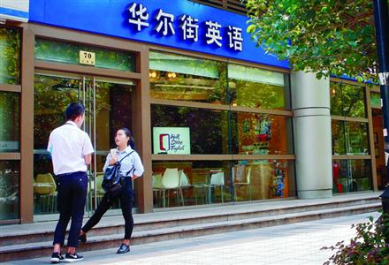 位于汇川路上的华尔街英语门店前,工作人员正在大街上向路人推销。/晨报记者 张佳琪