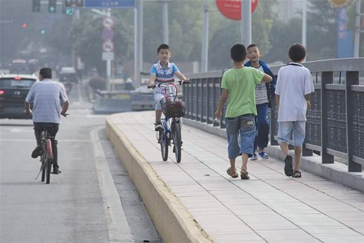 图文:小学生人行道上骑车逆行危险!