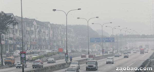 吉隆坡昨天的空氣污染指數居高不下，道路能見度大大減低，許多車輛都放慢行駛速度，以免發生意外。（中國報）