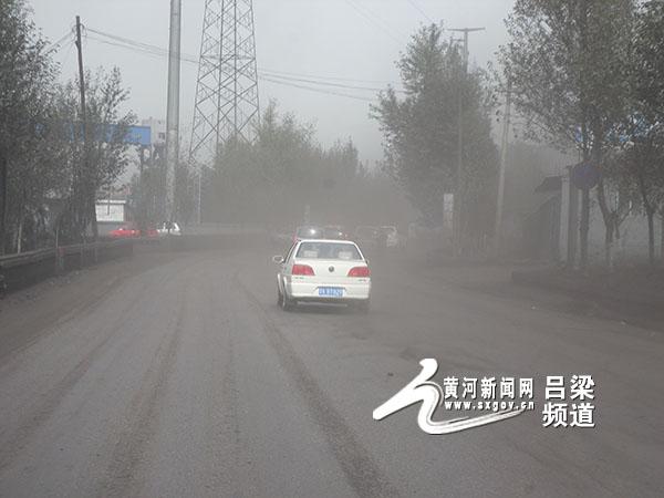 市交口县桃红坡镇境内道路交通拥堵车辆缓慢通行,沿路灰尘漫天飞扬,给