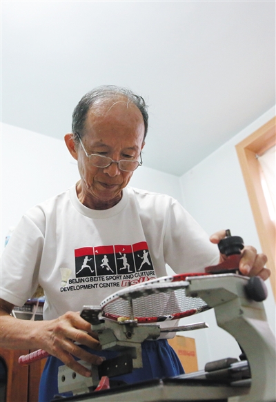 9月27日下午,朱宏在自己的器材室内穿球拍线。