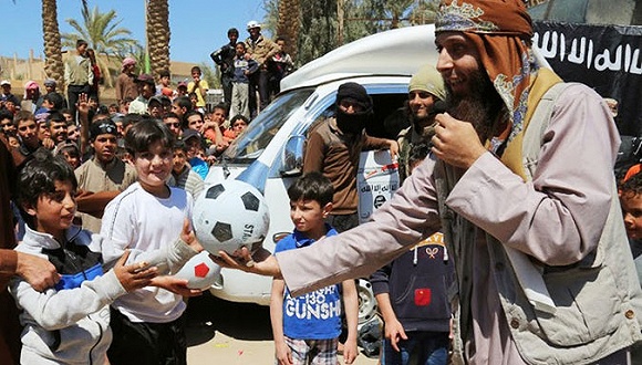 在这张isis发布的照片中,一名叙利亚isis成员在某活动中将足球递给一