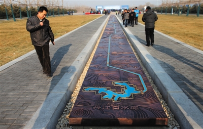 2014年12月27日,南水北调中线一期工程总干渠终点团城湖明渠,一位男士欣赏南水北调流经区域地图,北京市南水北调工程正式通水。新京报记者 薛珺 摄