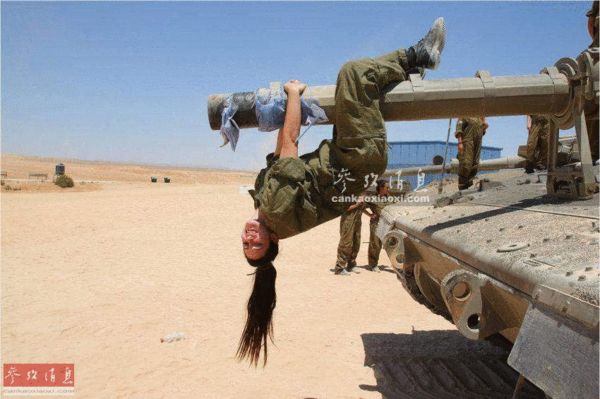 原文配图：倒挂在“梅卡瓦”坦克炮管上玩耍的以军女兵。