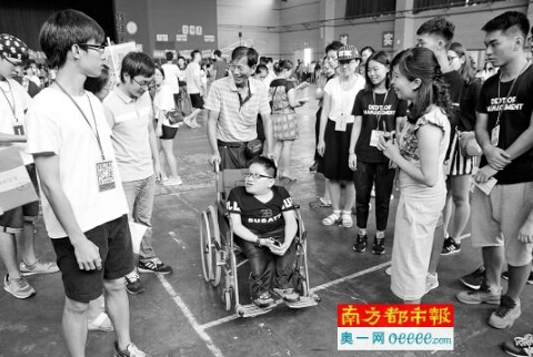 校园里，黄宋齐推着轮椅上的儿子黄耀辉。