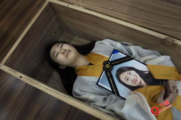 韩国设死亡学校 生者穿寿衣躺棺材