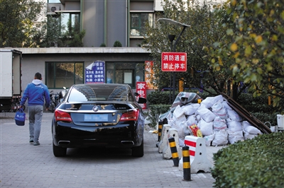 10月30日，朝阳区东恒时代小区一期，一辆汽车停放在消防通道上，旁边还堆放着建筑垃圾。 新京报记者 薛珺 摄