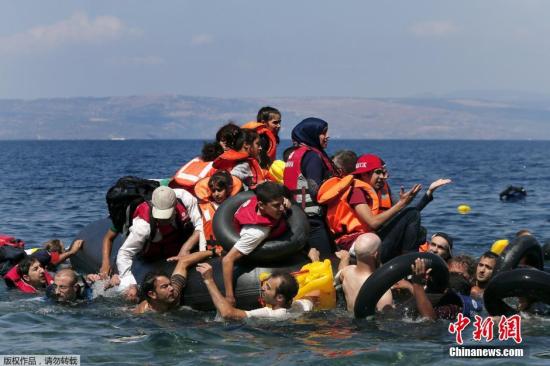 资料图：当地时间2015年9月13日，希腊莱斯博斯岛，承载叙利亚和阿富汗难民的一橡皮艇在靠近莱斯博斯岛100米远处泄气，当地民众和志愿者对难民进行了援助，难民们靠救生圈和游泳上岸。