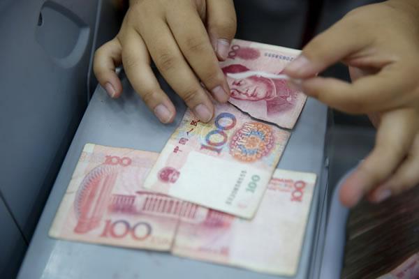 在南京钞票处理中心清分车间里工作人员正在粘贴残缺的人民币