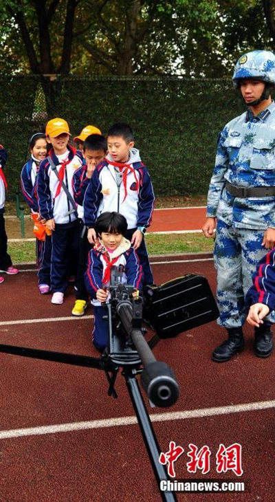 图为武汉小学生体验高射机枪.