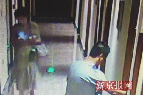 韩某打开房门,长发女子跟在其后。监控视频截图