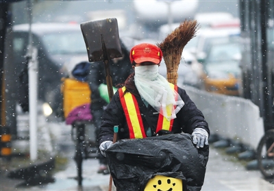 昨日北京迎来第二场雪,方庄街头,一位环卫工人雪中骑车。新京报记者 尹亚飞 摄