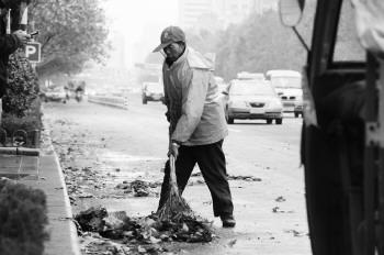 负责道路保洁的环卫工在车水马龙的道路上清洁道路,无时不刻都处在危险之中。