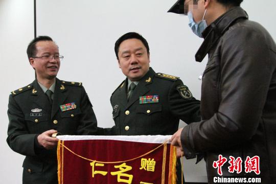 患者丈夫向患者母亲献花表示感谢。 记者 张远 摄