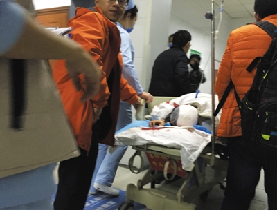 昨日,306医院急诊室内,一位伤势较重的学生躺在担架上准备办理住院手续。