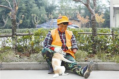 安徽省安庆市，方文英工作的空隙，一只流浪狗陪伴着她。这只狗每天凌晨开始，陪伴着方文英清扫马路。为了供女儿上大学，方文英一天要做三份保洁工作，长达16个小时的工作让她像机器一样连轴转。 楚接舆 摄/视觉中国