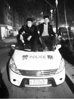 不作不会死 两男子醉酒装酷坐警车顶拍照被拘