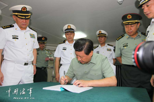 图为2013年9月1日，习近平观看舰载机滑跃起飞，在辽宁舰上为官兵签名留念。