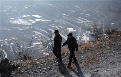 1月2日，民警程立新（左一）和民警李树合走在山路上巡山。本版摄影/新京报记者 王贵彬