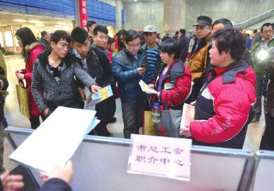 市总工会现场为刚刚下车的外地务工人员解答各种关于在北京务工问题。（资料图片）京华时报记者张斌摄