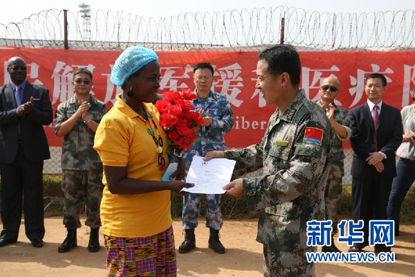 这是2015年3月5日,在利比里亚首都蒙罗维亚,埃博拉确诊病例患者亚杜罗(左)经过中国埃博拉治疗中心救治后拿到出院证书。她是中国埃博拉治疗中心以及利比里亚全国17家埃博拉治疗中心中最后一名治愈的患者。新华社发(李斌摄)
