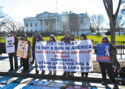 1月4日，美国华盛顿，示威者在白宫前举着标语，参加关于枪支使用安全和防止枪支暴力的集会。 新华社记者 鲍丹丹 摄