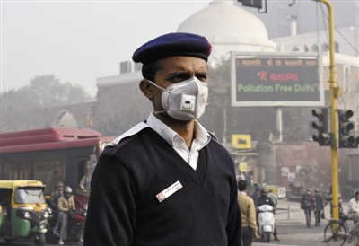 1月4日，新德里实行汽车单双号限行措施，工作人员戴口罩检查车辆是否违规。
