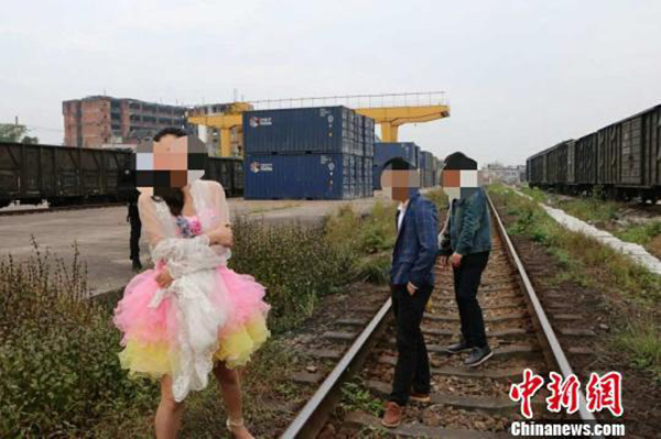 一对新人拍婚纱照逼停火车被广东惠州铁路警方处罚。 中新网 图