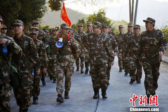 武警福建总队政委吕能亚(中)行军途中向战士了解情况 李涛 摄