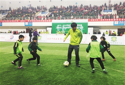 国安队员各率两名小学生在开展3人制足球赛。