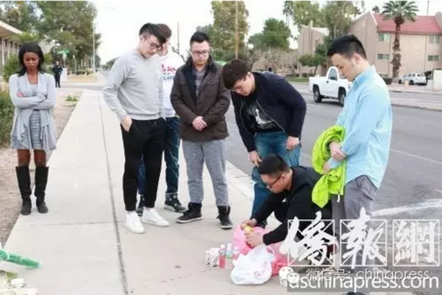 18日下午,陈恩东带了一些江玥生前爱吃的零食,来到事发地点看望江玥(半蹲在中间的为陈恩东)(侨报记者李帜一摄)