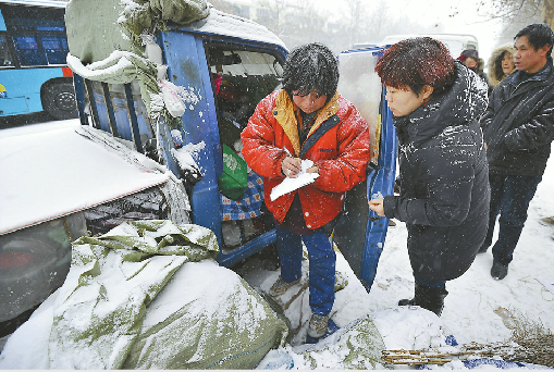 工作人员在街头劝说流浪女左一进入救助站避寒记者郭尧 实习生刘玉乐