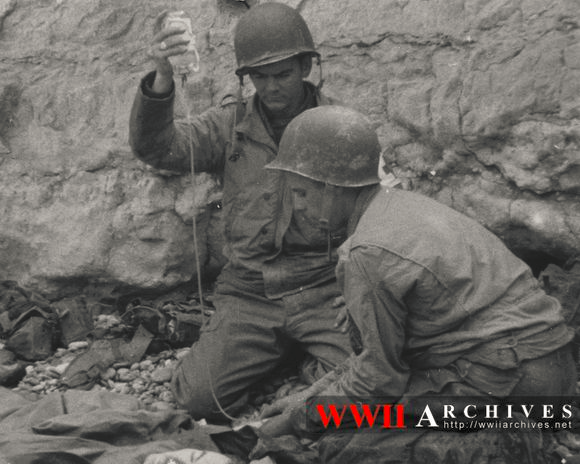 (1944年6月8日,一名医护兵正在为伤兵输血)在二战中,虽然一开始美国没
