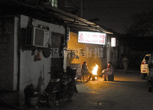 几家旅店的店主在门外烤火等待主顾。