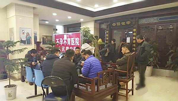 “不明身份人士”在病院内围聚打牌。