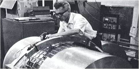 图4：韦伯和他设计的共振棒探测器。引力波驱动铝棒两端振动，从而挤压表面的晶片，产生可测的电压。